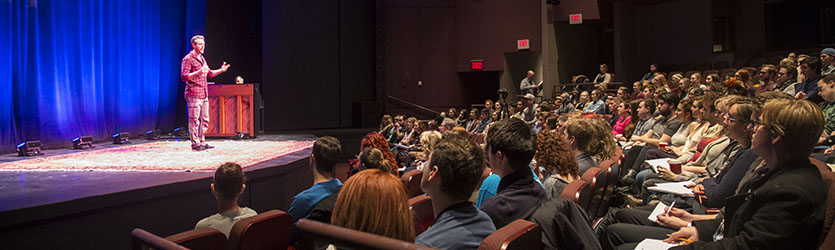 Adam Pascal on stage, talking to a room full of students in the Festival Playhouse