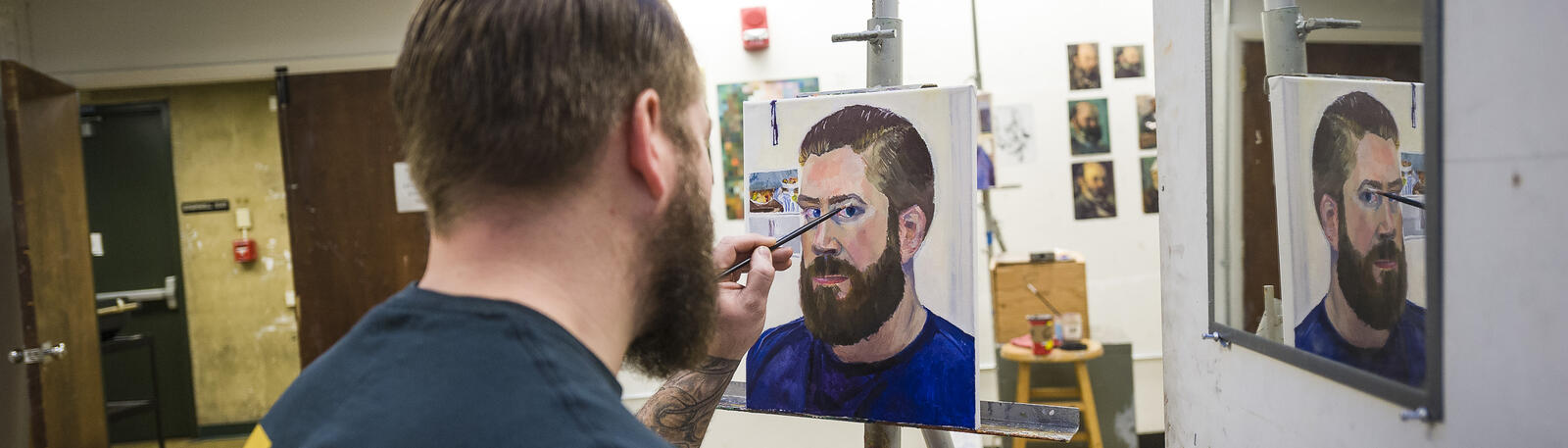 photo of an art student painting in a studio at wright state