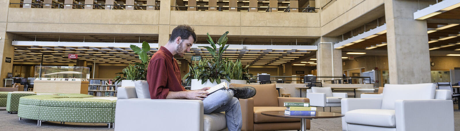 photo of a student reading a book in the library at wright state