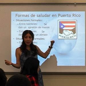 Spanish professor presenting slide about Puerto Rico in front of high school classroom