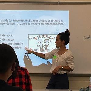 Spanish professor presenting slide about Puerto Rico in front of high school classroom